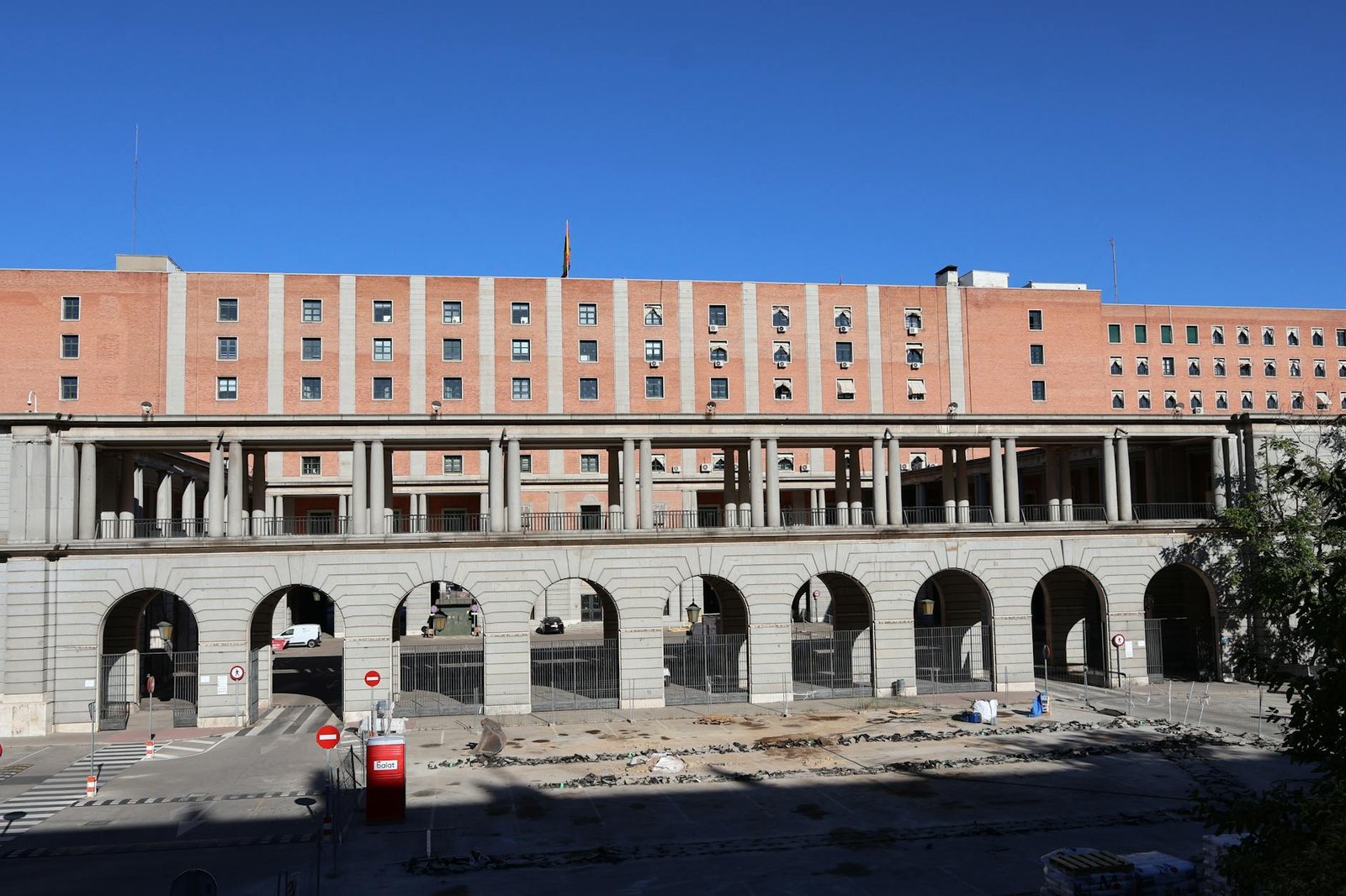 View of a historic building with arches and a walkway on a sunny day in Madrid.