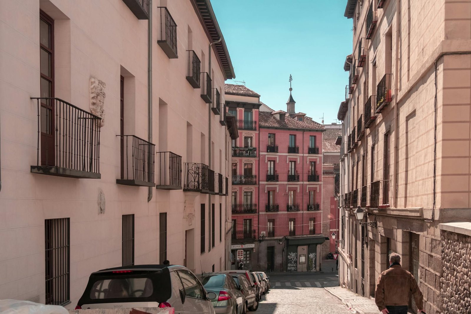 Discover a quaint street in Madrid with classic architecture and a warm atmosphere.