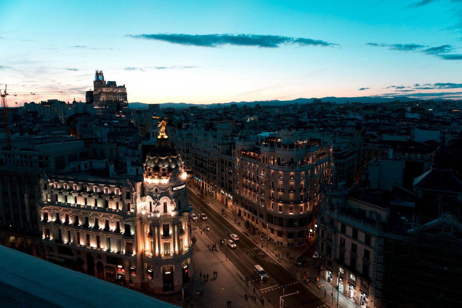 A stunning view of Madrid cityscape during twilight with beautifully illuminated buildings and clear skies.