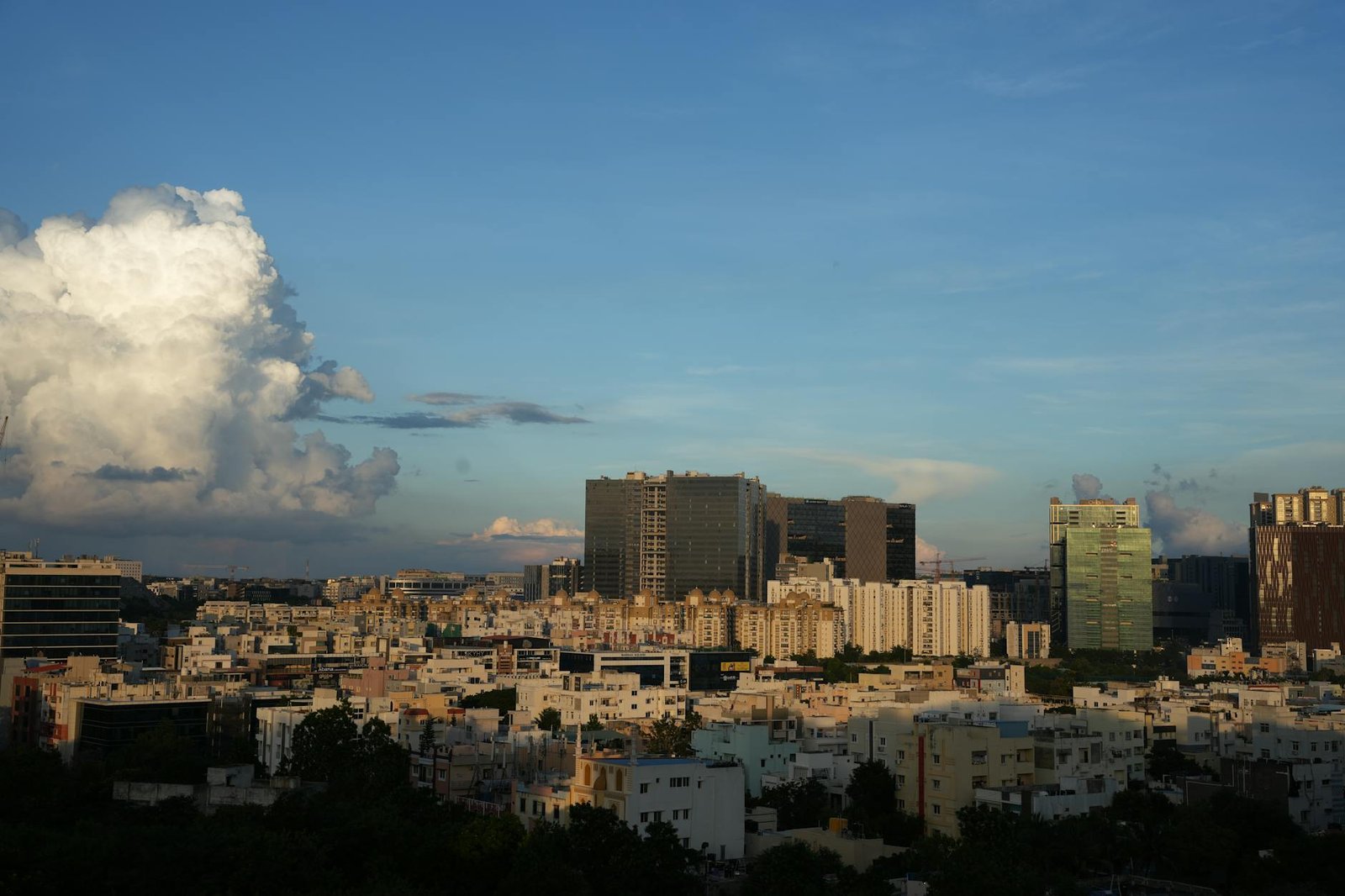 Dynamically lit urban skyline featuring modern buildings against a twilight sky with dramatic clouds.
